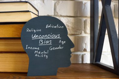 Stack of books and a head with an inscription unconscious bias. clipart