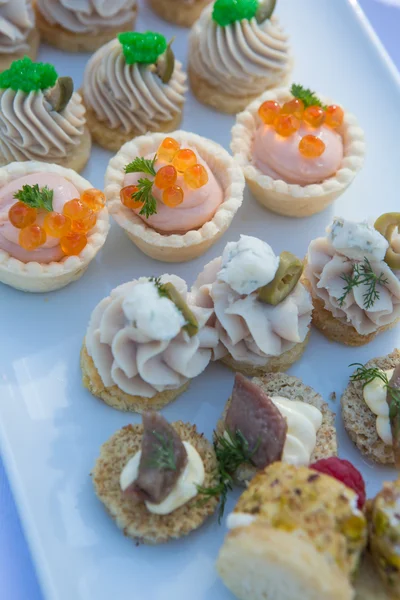 Deliciosos canapés de aperitivo a bordo para la mesa de celebración —  Fotos de Stock