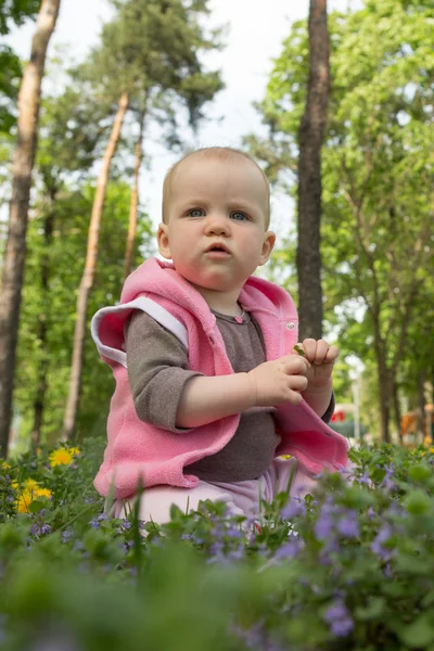 Kis baba, egy napsütéses napon a parkban, a füvön játszó — Stock Fotó