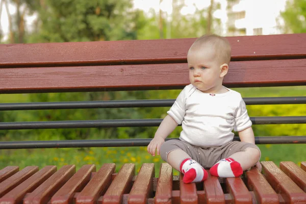 Jovem adorável alegre bebê sentar no parque — Fotografia de Stock