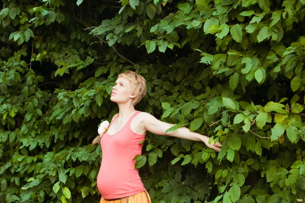 Ung, lykkelig, gravid kvinne som slapper av i naturen – stockfoto