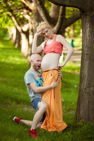 Happy and young pregnant couple hugging in nature, new life conc — Stock Photo, Image