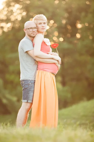 Happy and young pregnant couple hugging in nature, new life conc — Stock Photo, Image