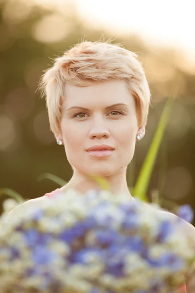 Портрет улыбающейся молодой женщины с цветами — стоковое фото