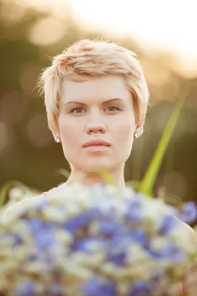 Portrait of a smiling young woman with flowers — Stock Photo, Image