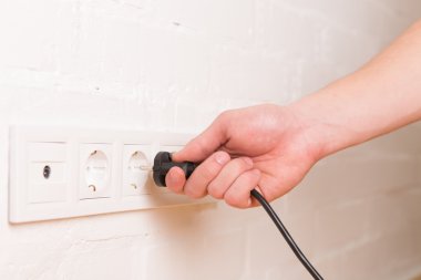 pull the plug concept with man pulling black cord and plug clipart