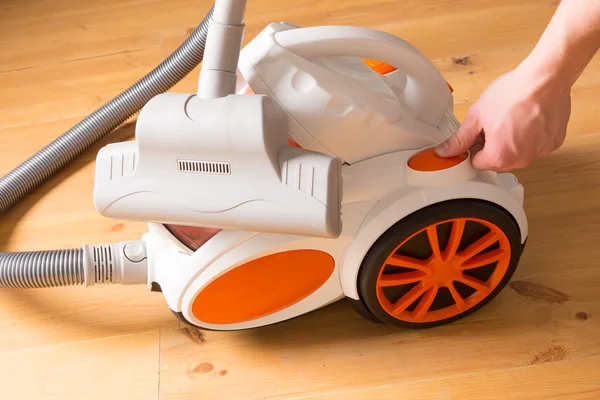 Closeup of a hand to turn on the vacuum cleaner. Man is unrecogn — Stock Photo, Image