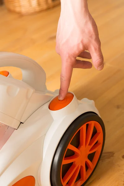 Closeup of a hand to turn on the vacuum cleaner. Man is unrecogn — Stock Photo, Image