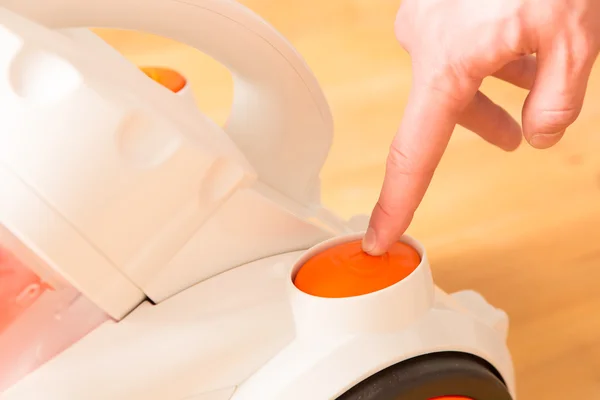 Closeup of a hand to turn on the vacuum cleaner. Man is unrecogn — Stock Photo, Image