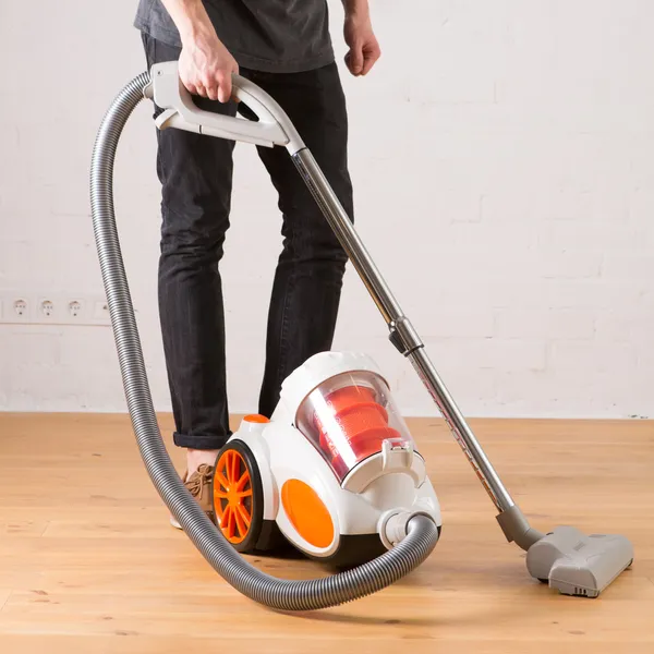 cleaning with vacuum cleaner in living room