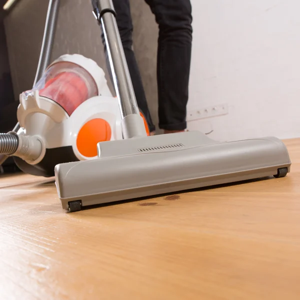 cleaning with vacuum cleaner in living room