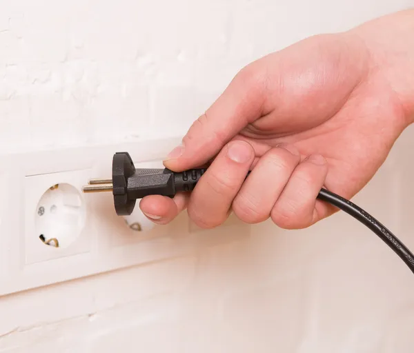 Pull the plug concept with man pulling black cord and plug — Stock Photo, Image
