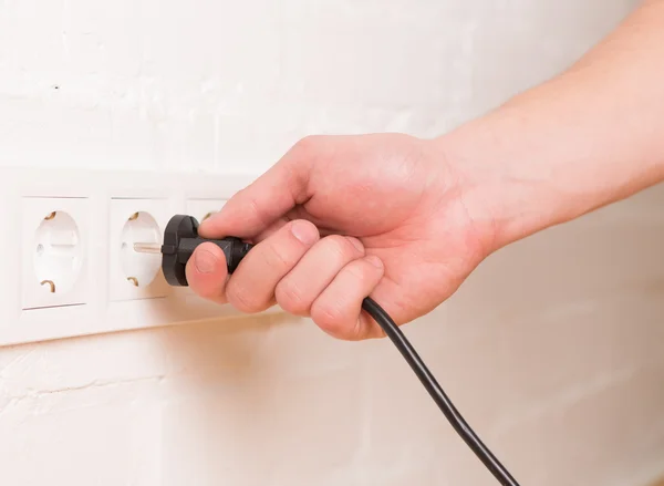 Pull the plug concept with man pulling black cord and plug — Stock Photo, Image