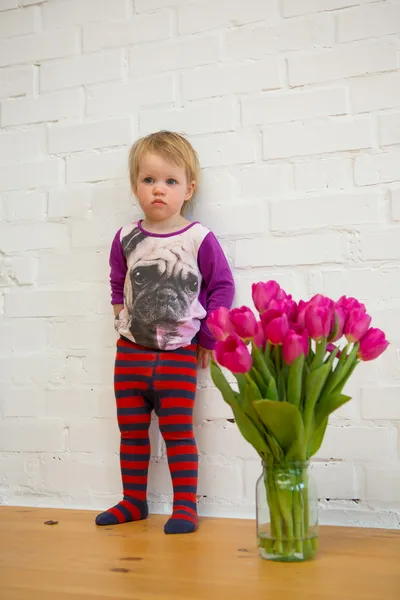 Glückliches Kind mit Tulpen — Stockfoto