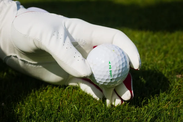 Hand hält Golfball mit Abschlag auf dem Platz, Nahaufnahme — Stockfoto