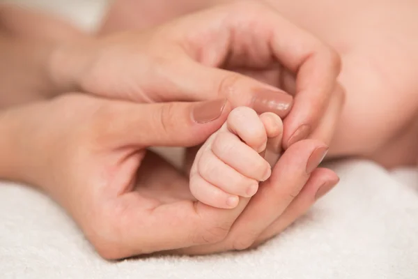 La mano del bebé agarrando dedo adulto — Foto de Stock