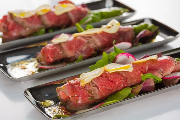 Rindfleisch-Carpaccio mit Salatblättern und Gemüse. Leckerer Appetit — Stockfoto