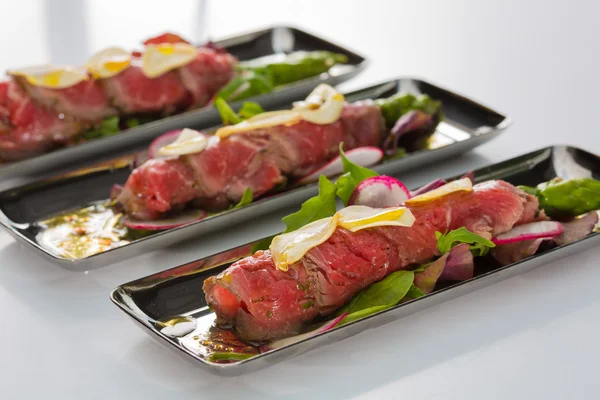 Rindfleisch-Carpaccio mit Salatblättern und Gemüse. Leckerer Appetit — Stockfoto