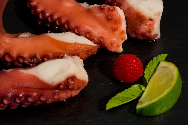 Cooked Octopus Plate with lime in black stone background — Stock Photo, Image