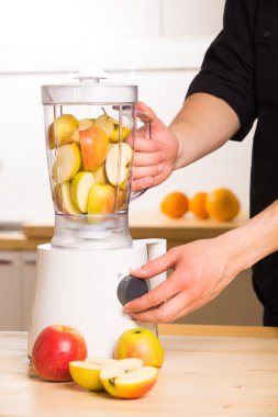 Elmalı ahşap bir masa üzerinde beyaz blender.
