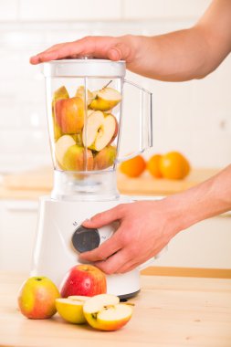 Elmalı ahşap bir masa üzerinde beyaz blender.