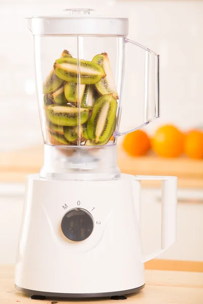 Witte blender met kiwi op een houten tafel — Stockfoto