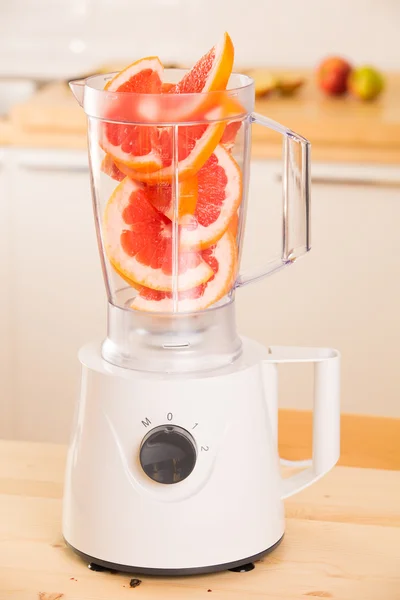 Grapefruit witte blender op een houten tafel. — Stockfoto