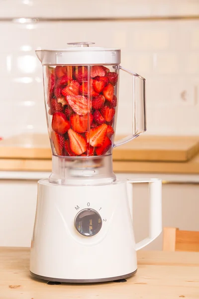 Fresh strawberries in white Blender on a wooden table — Stock Photo, Image