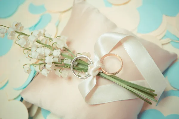 Anéis de casamento de ouro branco com um buquê — Fotografia de Stock