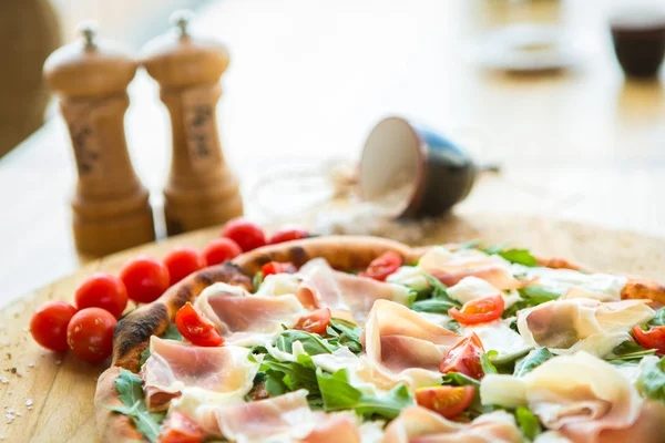 Pizza with cherry tomatoes, prosciutto and ruccola — Stock Photo, Image