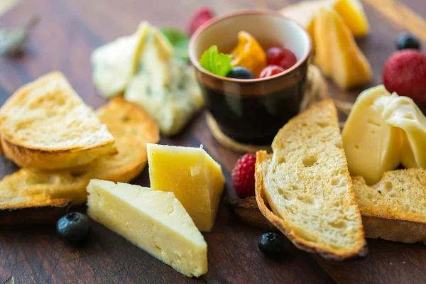Assorted cheese on a wooden board. — Stock Photo, Image