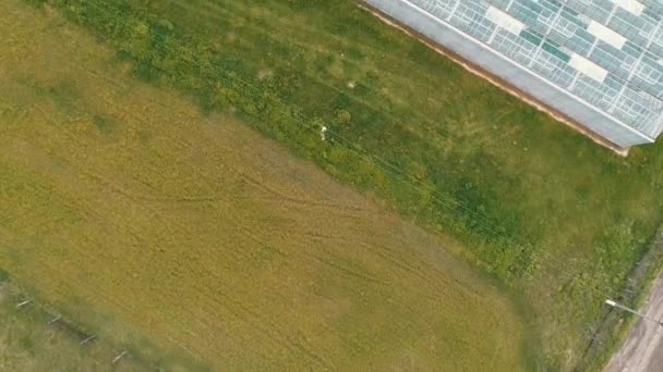 Bovenaanzicht vanuit de lucht van de kas - openingszicht. Camera beweegt vooruit over de massieve glazen constructie. Biologische landbouw binnenshuis, warmteterugwinning, stroomverbruik concept. Achtergrond video, kopieer ruimte — Stockvideo