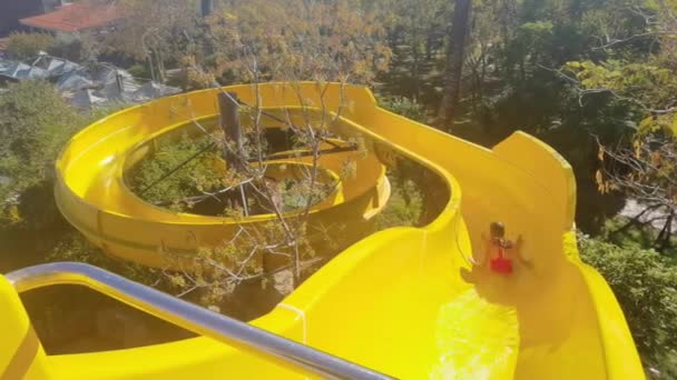 Dziewczyna Zabawia Się Na Wodnych Zjeżdżalniach Aqua Park Glides. Funny Ride On Water Slide Pool w parku wodnym. Przesuwanie się w dół w parku wodnym — Wideo stockowe