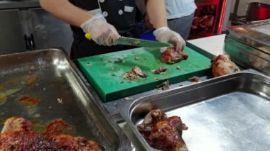 Şef ızgara tavuğu keser, yakın çekimde chiken keser, ızgara tavuğu yavaş çekimde doğrar, kızarmış tavuk keser.