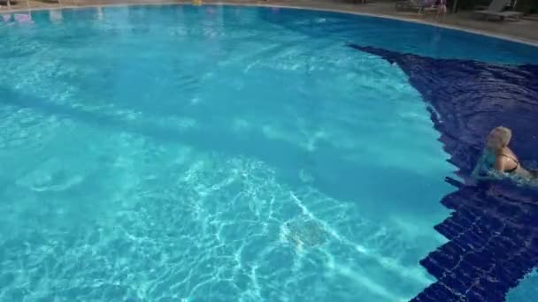 Mujer joven y activa buceando en la piscina y salpicando agua. Señora relajante en resort tropical. — Vídeos de Stock