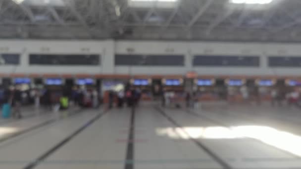 机场内排起了大队，戴着口罩的乘客排队检查大流行病期间的护照。在机场办理登机手续的柜台前，乘客登记的录像资料模糊不清。 — 图库视频影像