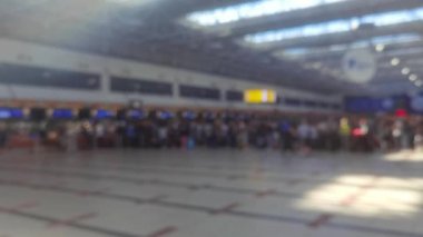 Havaalanında büyük bir kuyruk var, maskeli yolcular salgın sırasında pasaport kontrolü için kuyrukta bekliyorlar. Bulanık odaklı video stok yolcuları check-in gişesinde check-in