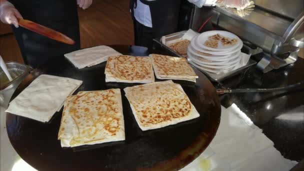 En äldre kvinna lagar traditionella turkiska gozleme tortillas med kött i det fria — Stockvideo