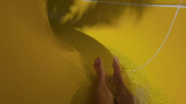 Personne masculine méconnaissable chevauchant la glissière de tube d'eau dans l'aquapark. Attraction rapide de l'eau. Vue sur les jambes sur l'aire de jeux. Slider voyage vers le bas diapositive très rapidement. Météo chaude dans les parcs aquatiques récréatifs — Video