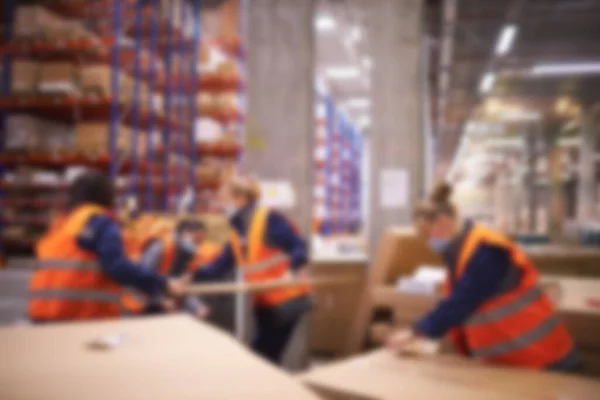 Blur warehouse background. Warehouse worker taking package in the shelf in a large warehouse in a large warehouse — Stockfoto