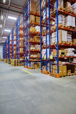 Huge distribution warehouse with high shelves and loaders.