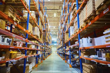 Huge distribution warehouse with high shelves and loaders.