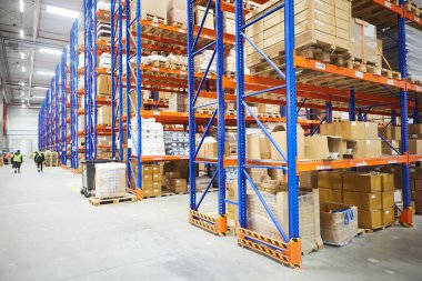 Huge distribution warehouse with high shelves and loaders.