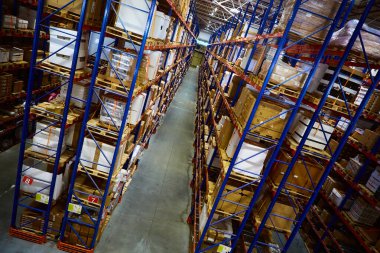 Huge distribution warehouse with high shelves and loaders.