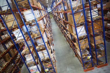 Huge distribution warehouse with high shelves and loaders.
