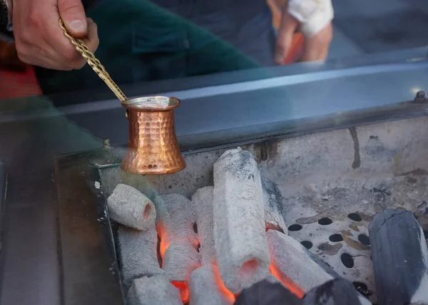 Une cafetière turque sur du bois brûlant avec du café à l'intérieur. — Photo