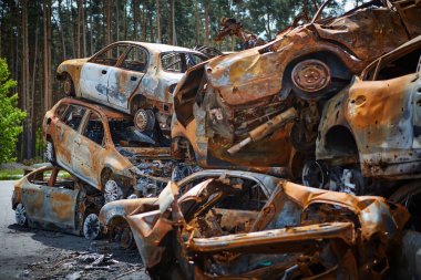 Rus ordusu tarafından vurulduktan sonra Irpen 'de bir sürü paslı yanmış araba var. Rusya 'nın Ukrayna' ya karşı savaşı. Savaş bölgesinden kaçmaya çalışan sivillerin tahrip edilmiş arabalarının mezarlığı..