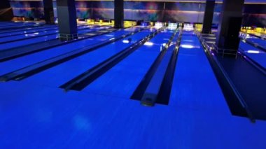 Bir kadın piste bowling topu atıyor..