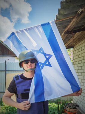 İsrail askeri, İsrail bayrağını önünde tutuyor. Kavram: İsrail Anma Günü, Yahudi Soykırımı Anma Günü, İsrail 'de Bağımsızlık Günü
