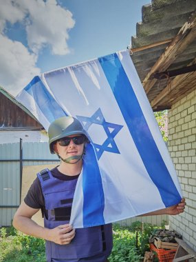 İsrail askeri, İsrail bayrağını önünde tutuyor. Kavram: İsrail Anma Günü, Yahudi Soykırımı Anma Günü, İsrail 'de Bağımsızlık Günü